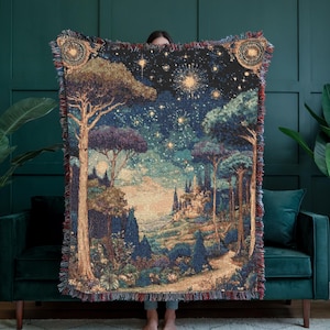 Puede incluir: Manta tejida con tapiz que presenta una escena detallada de un paisaje con árboles, un camino y un cielo estrellado. La manta tiene un borde con flecos y diseños decorativos en las esquinas. La paleta de colores incluye azules, verdes y marrones.
