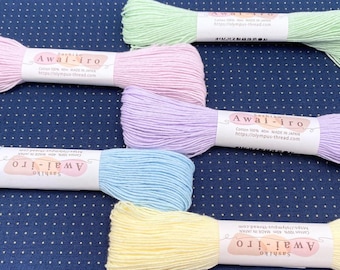 May include: Five skeins of Sashiko Awai-iro embroidery thread in pastel green, pink, lavender, blue, and yellow. Each 40m cotton thread bundle features a white paper label with the text Sashiko Awai-iro, Cotton 100%, 40m, MADE IN JAPAN.