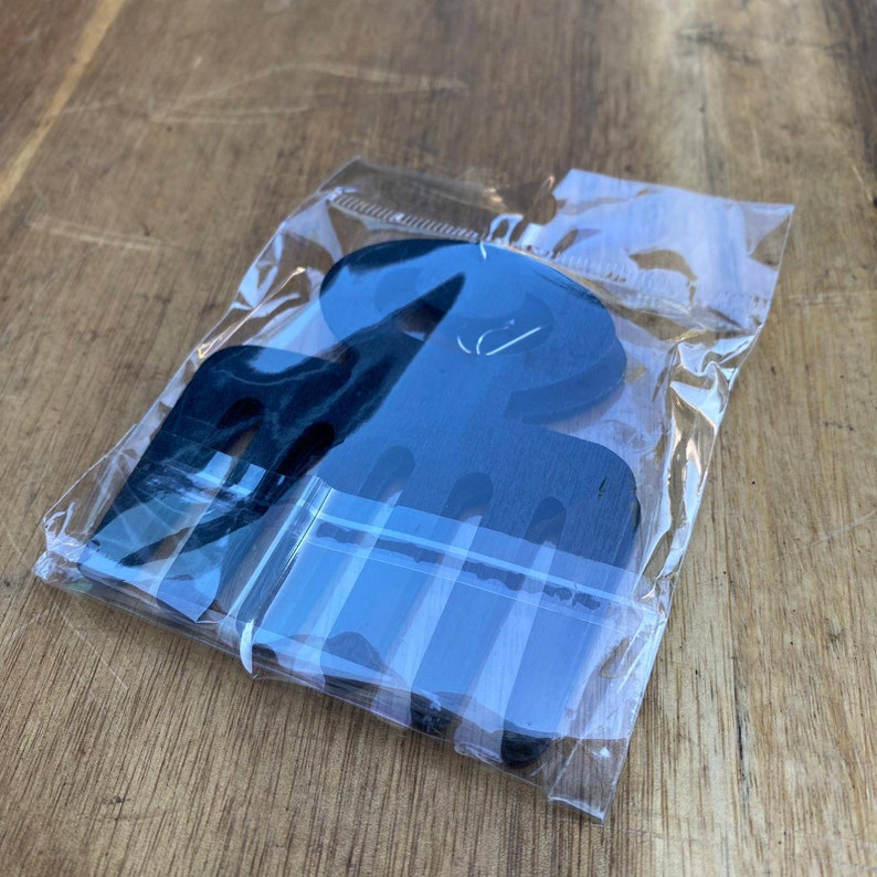 May include: A set of black paper cutouts in the shape of an octopus, packaged in a clear plastic bag.