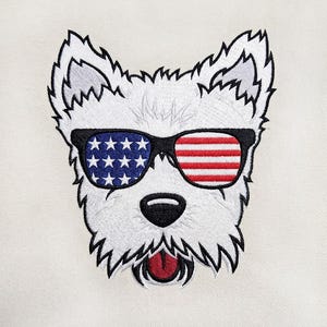 Könnte beinhalten: Ein gestickter Aufnäher eines weißen West Highland Terrier-Kopfes mit einer schwarz umrandeten Sonnenbrille. Das linke Glas zeigt weiße Sterne auf blauem Grund, das rechte Glas rote und weiße Streifen. Der Hund hat eine schwarze Nase und rote Zunge.