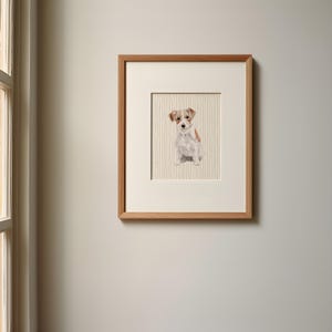 Può includere: Una stampa incorniciata di un dipinto ad acquerello di un piccolo cane bianco e marrone seduto su uno sfondo a righe.