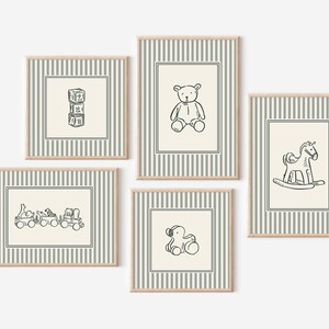 May include: Five framed prints with illustrations of classic toys. Each print has a cream background with a black and white drawing of a toy, such as building blocks, a teddy bear, a rocking horse, a train, and a dog. The frames have a striped pattern.