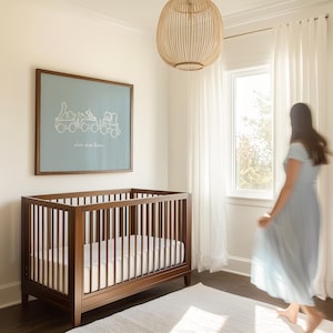 May include: A nursery scene featuring a dark wood crib with a white mattress, a framed blue print with a train illustration, and the text "choo choo train". A woven light fixture hangs above. White curtains and a rug complete the room.
