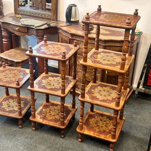 Może przedstawiać: Drewniane, wielopoziomowe stojaki na rośliny ze skomplikowanymi wzorami kwiatowymi. Stojaki są w różnych rozmiarach i mają wiele półek. Drewno ma ciepły brązowy kolor z dekoracyjnymi akcentami. Idealne do roślin.