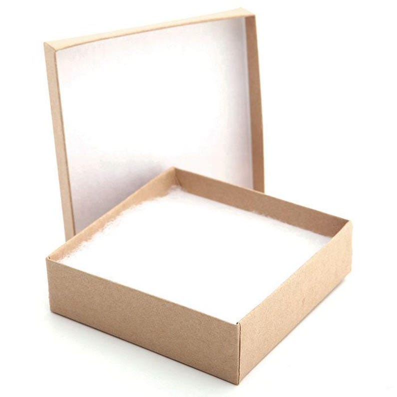 May include: An open, empty, rectangular cardboard box with a white interior and a separate lid. The box is light brown and contains a white, fluffy material inside. The lid is slightly ajar, revealing the box's contents.