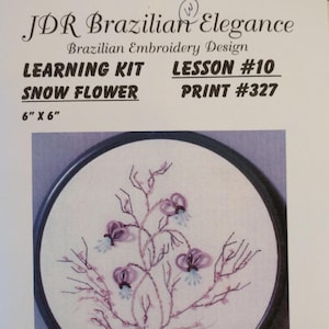 May include: Brazilian embroidery learning kit featuring a floral design. The kit includes fabric, needles, threads, and instructions. The design is labeled "Snow Flower" and measures 6" x 6". The kit is Lesson #10, Print #327.