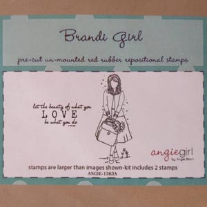 May include: A teal and white card features the text "Brandi Girl" and "pre-cut un-mounted red rubber repositional stamps." The card includes a black and white illustration of a woman holding a bag. The text "Let the beauty of what you LOVE be what you do" is also included.