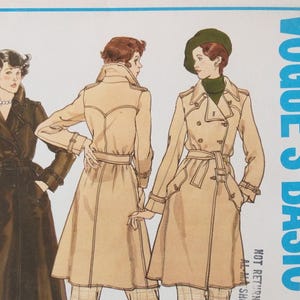 May include: A Vogue's Basic sewing pattern envelope illustration featuring three trench coats in tan and dark brown. The coats have double-breasted fronts, belted waists, epaulets, and long sleeves with buckled cuffs. The text reads VOGUE'S BASIC.