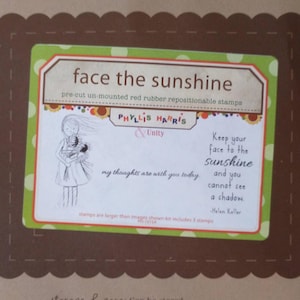 May include: A package of pre-cut, unmounted red rubber repositionable stamps. The green and white label features the text "face the sunshine" and a drawing of a girl holding flowers. A quote by Helen Keller is also included.