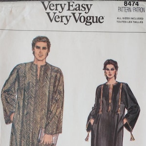 May include: A vintage sewing pattern from Very Easy Very Vogue, pattern number 8474. The pattern features illustrations of two long-sleeved garments. One is a patterned tunic, and the other is a black dress with gold trim and tassels.