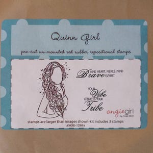 May include: A package of "Quinn Girl" pre-cut, unmounted red rubber repositional stamps. The design features a line drawing of a woman with long hair, and the words "Brave Spirit", "Your Vibe Attracts Your Tribe", and "angiegirl".
