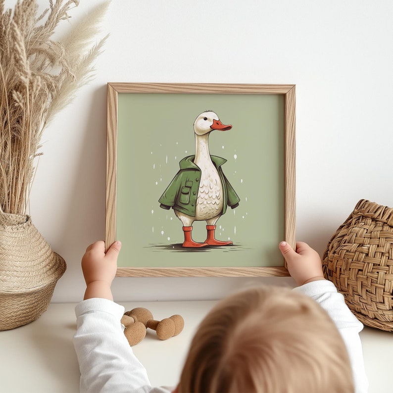 May include: A framed illustration of a white goose wearing a green jacket and red boots on a green background.