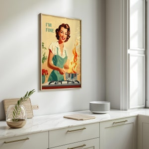 May include: A vintage-style poster featuring a woman in a green apron cooking on a stove. The stove is on fire and the woman is smiling and saying "I'm Fine".