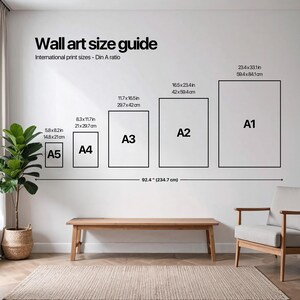 Puede incluir: Una gu&iacute;a de tama&ntilde;os de arte mural con tama&ntilde;os de impresi&oacute;n internacionales, A5, A4, A3, A2 y A1, con dimensiones en pulgadas y cm. La gu&iacute;a est&aacute; en una pared blanca sobre un banco y una alfombra de madera, con una planta y una silla.