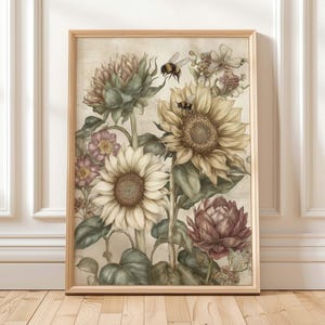 Puede incluir: Una impresi&oacute;n bot&aacute;nica enmarcada con girasoles, abejas y otras flores en tonos crema, amarillo y burdeos. La obra de arte tiene una est&eacute;tica vintage, con un fondo beige claro y un marco de madera. Una pieza decorativa para la decoraci&oacute;n del hogar.