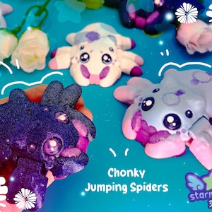 May include: A collection of colorful, cartoonish "Chonky Jumping Spiders" in various shades of purple, pink, and white. The spiders have large, expressive eyes and are arranged on a light blue surface with decorative floral accents. The "starmouse 3D" logo is visible.