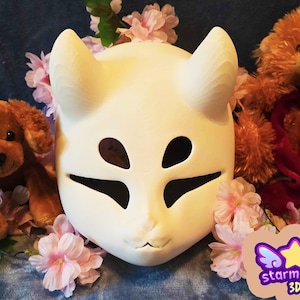 Op de afbeelding: Een crèmekleurig, vosachtig masker met grote oorachtige uitsteeksels en uitsparingen voor ogen en mond. Het masker is omgeven door roze bloemen en knuffels. Het Starmouse 3D-logo staat rechtsonder.