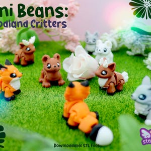 Puede incluir: Una colección de figuritas de animales del bosque en miniatura, incluyendo un zorro, un oso, un ciervo y un conejo, dispuestas sobre una superficie verde. Las figuritas son de colores brillantes y tienen un diseño de dibujos animados. El texto "Mini Beans: Woodland Critters" es visible.