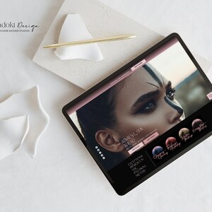 May include: A tablet computer displaying a website for a design studio called "Lunadoli Design." The website features a close-up image of a woman's face with dramatic makeup and the text "Always Look Ahead." The website also includes a section titled "Exceptional Muse in the Following Matter."