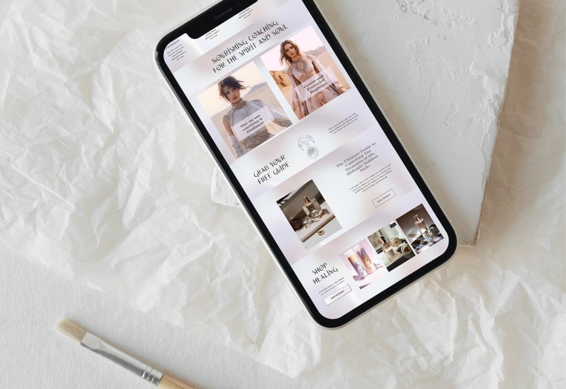 May include: A smartphone displays a website with the text "Nourishing Coaching for the Spirit and Soul." The site features images of women, products, and the phrases "Grab Your Free Guide" and "Shop Healing."
