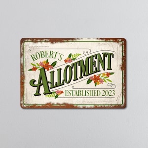 May include: A rectangular metal sign with a distressed, rustic design. The sign reads "ROBERT'S ALLOTMENT ESTABLISHED 2023" in green and cream lettering, with floral accents. The border is brown.