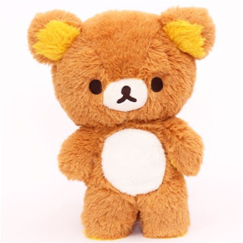 May include: A brown plush bear with yellow ears and a white belly. The bear has a friendly expression and is standing on all fours.