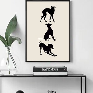 Pu&ograve; includere: Una stampa in bianco e nero di tre silhouette di levrieri italiani in diverse pose. La stampa &egrave; incorniciata in una cornice nera e appesa a una parete bianca.