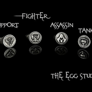 May include: Set of silver rings with different symbols representing different roles in a game. The roles are: ADC, Support, Fighter, Assassin, Tank, and Mage. The rings are displayed on a black background with the text "The Egg Studio" at the bottom.