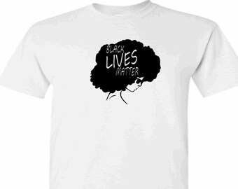 Może przedstawiać: Biała koszulka z czarną sylwetką kobiety z afrykańskim fryzurą. Tekst "Black Lives Matter" jest napisany na afro.