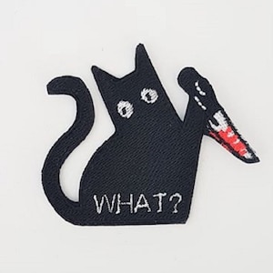 Peut inclure: Patch thermocollant brodé noir représentant un chat tenant un couteau avec le texte "WHAT?" en dessous.