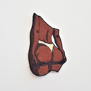 Puede incluir: Parche bordado de la espalda de una persona de piel morena con un bikini de tanga blanco.