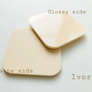 Pu&ograve; includere: Due pezzi quadrati di acrilico color avorio, uno con finitura lucida e l'altro con finitura opaca. Il lato lucido &egrave; etichettato "Glossy side" e il lato opaco &egrave; etichettato "Matte side".