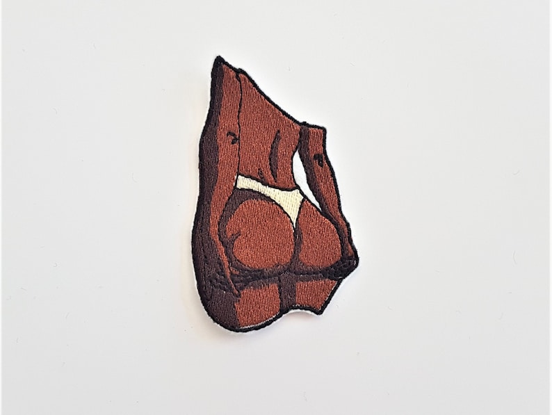 Puede incluir: Parche bordado de la espalda de una persona de piel morena con un bikini de tanga blanco.