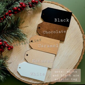 May include: Five different color gift tags, including black, chocolate, caramel, natural, and white. The white and black tags are acrylic, while the other tags are wood. The text "note: white and black are acrylic tag" is written below the tags.
