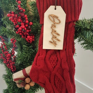 May include: Red knitted Christmas stocking with a wooden tag that says "Daddy" on a 14 inch stocking.