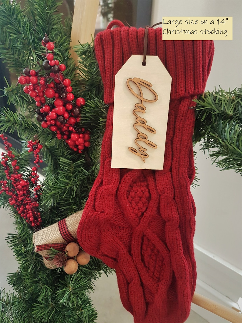 May include: Red knitted Christmas stocking with a wooden tag that says "Daddy" on a 14 inch stocking.