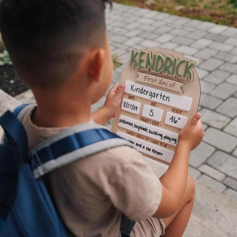 Child holding personalized first day of school sign, reusable wooden back to school board