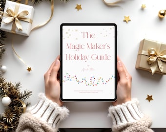 May include: A tablet displays "The Magic Maker's Holiday Guide" in red text, with a string of colorful lights at the bottom. The tablet is surrounded by Christmas decorations, including wrapped gifts, gold stars, and evergreen branches.