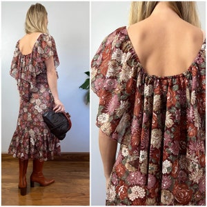 May include: A brown and pink floral print midi dress with a ruffled neckline and short sleeves. The dress has a gathered waist and a ruffled hem.