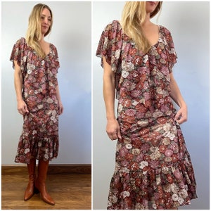 May include: A long, brown floral dress with a ruffled hem and short, ruffled sleeves. The dress has a V-neckline and a floral print in shades of pink, red, and white.