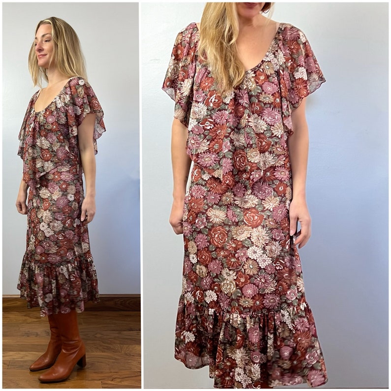 May include: A vintage floral print midi dress with a ruffled neckline and short sleeves. The dress has a tiered skirt with a ruffled hem and is made of a lightweight fabric.