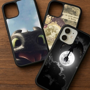 May include: Three black phone cases with different designs. One features a close-up of a dragon's face with green eyes against a blue sky. Another has a map and dragon illustration. The third shows a dragon silhouette against a full moon.