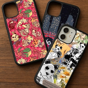 Puede incluir: Tres fundas para teléfono con bordes negros. Una funda presenta un fondo rosa con personajes de dibujos animados. Otra tiene un diseño de paisaje urbano con un puente rojo. La tercera funda tiene una ilustración de panda con el texto "Pretty brown eyes and a mind full of thoughts."