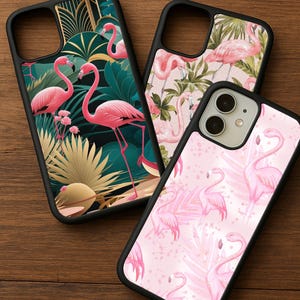 May include: Three phone cases with flamingo designs. One case features pink flamingos with tropical foliage on a black border. Another has a pink flamingo pattern on a pink background. The third case has pink flamingos and tropical leaves.