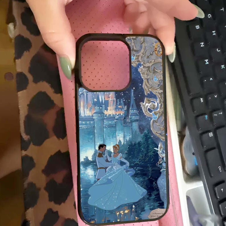 May include: A black phone case featuring a fairytale scene with a castle, a couple dancing, and a starry night sky. The case has a glossy finish and a protective bumper around the edges.