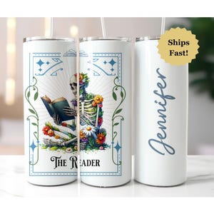 May include: A white stainless steel tumbler with a design of a skeleton reading a book surrounded by flowers. The text "The Reader" is below the skeleton. The tumbler is personalized with the name "Jennifer".