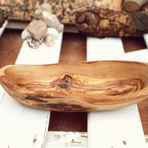 Irregular elongated bowl with organic shapes. boat-shaped bowl with irregular upper rims and natural bark from the trunk