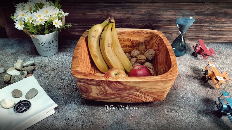 Salad bowl or square fruit bowl in olive wood with rounded corners, very original shape with a decreasing shape to the very beautiful base.  Fruit bowl stuffed with fruit