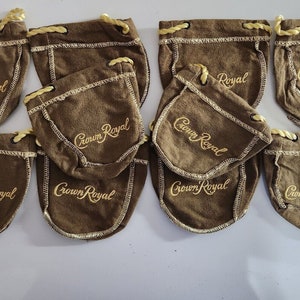 May include: Ten brown fabric drawstring bags with the text "Crown Royal" embroidered in gold on each bag.