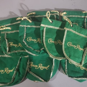 May include: A group of nine green velvet drawstring bags with gold embroidery that reads "Crown Royal".